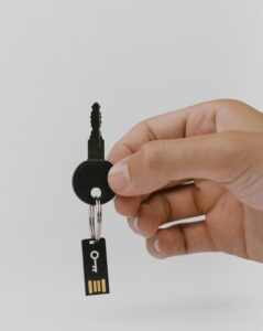 A hand holding a key with a USB flash drive.