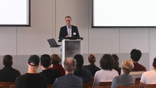 Image of Dr. Nicholas Weilinger speaking in front of audience during the Health Research BC-Mitacs media event in 2025.